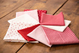 a pile of red and white fabric sitting on top of a wooden floor